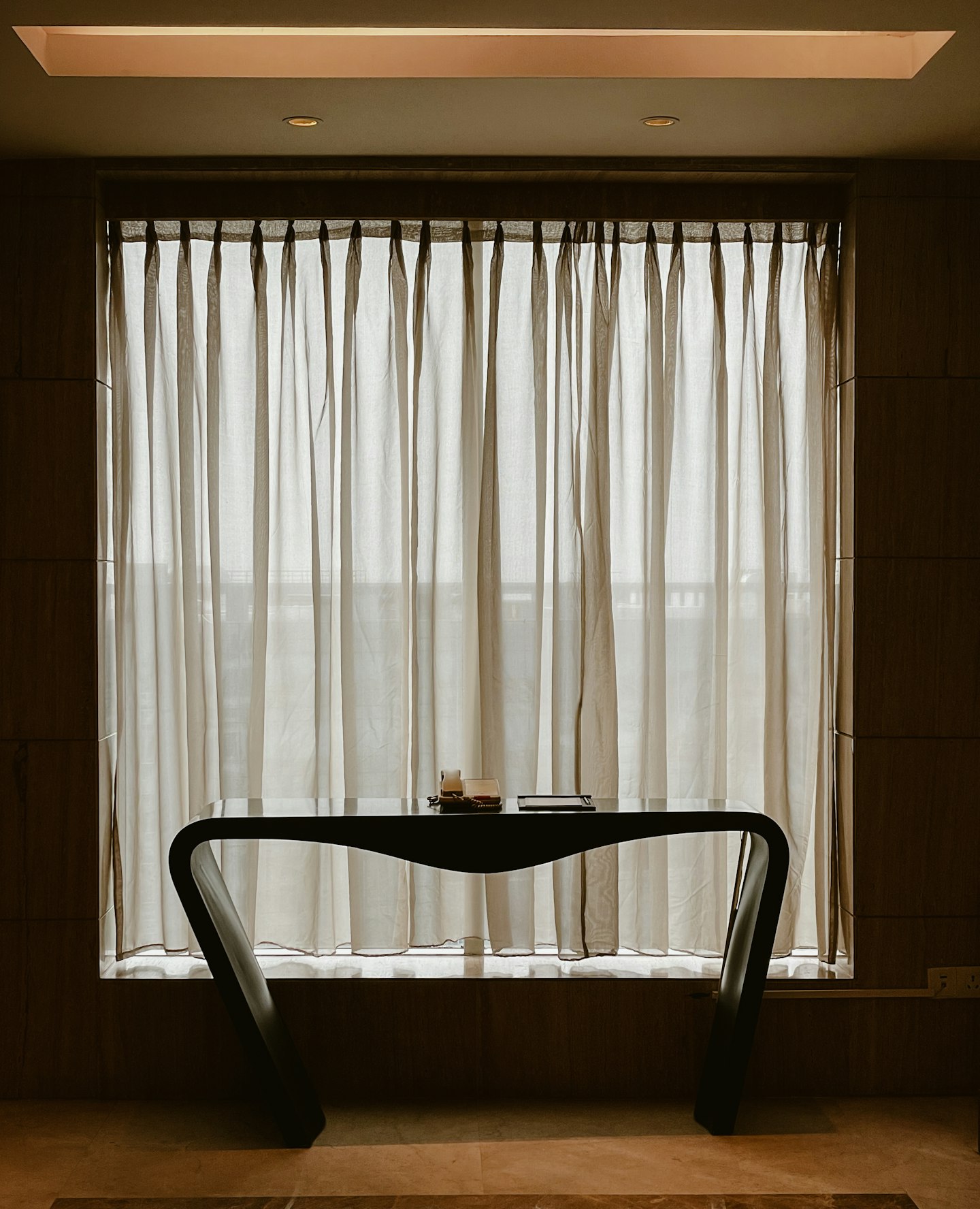 A chair in front of a linen curtain