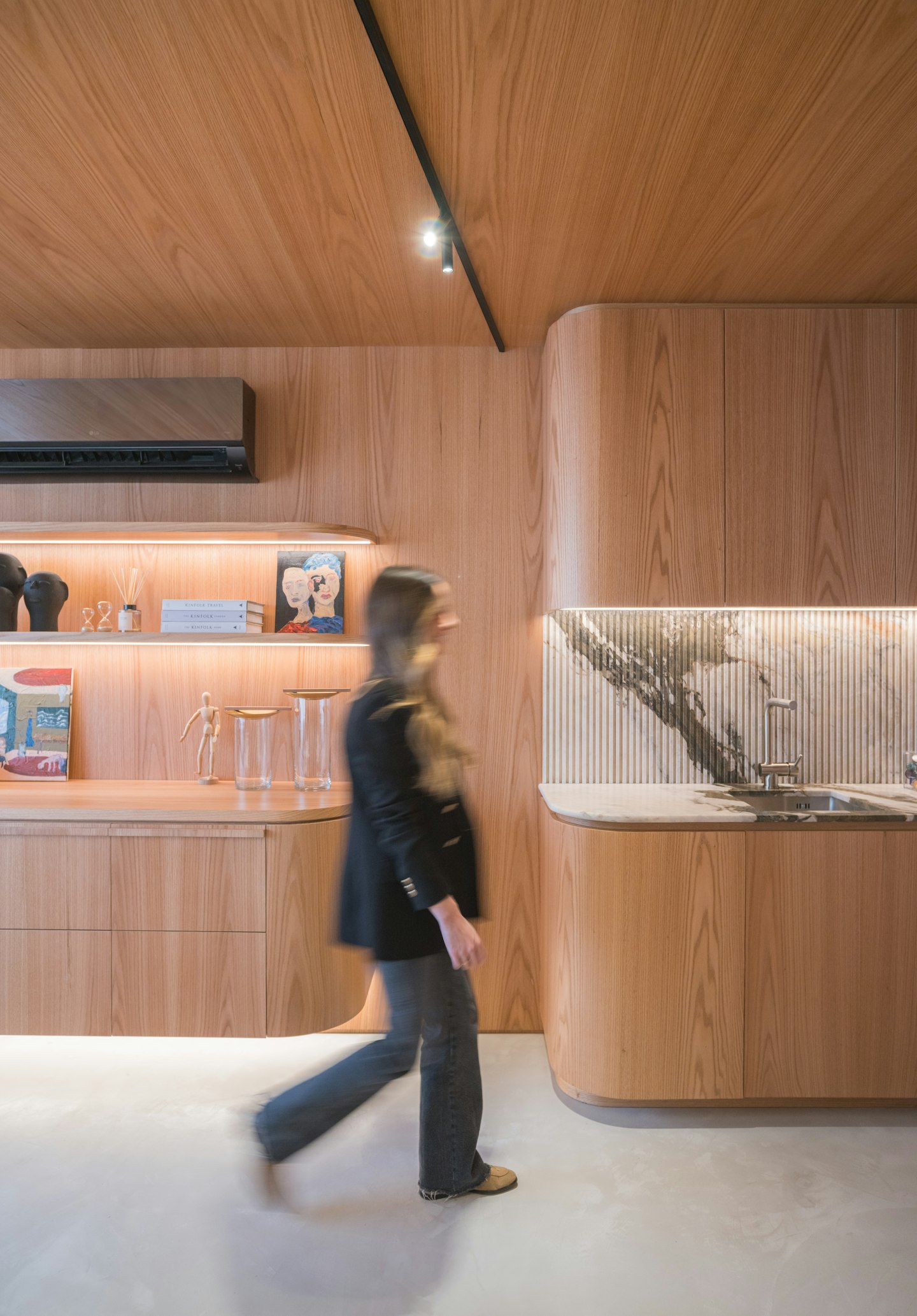 A person walking through a warm timber-clad office